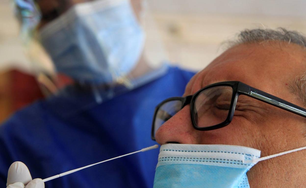 Un hombre con gafas se somete a una prueba PCR.