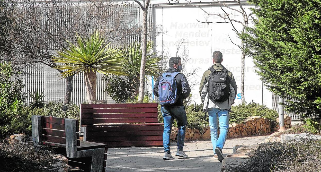 Dos estudiantes pasean por el campus de la Muralla de la Universidad Politécnica de Cartagena (UPT), frente al edificio de Investigación, Desarrollo e Innovación (I+D+i). 