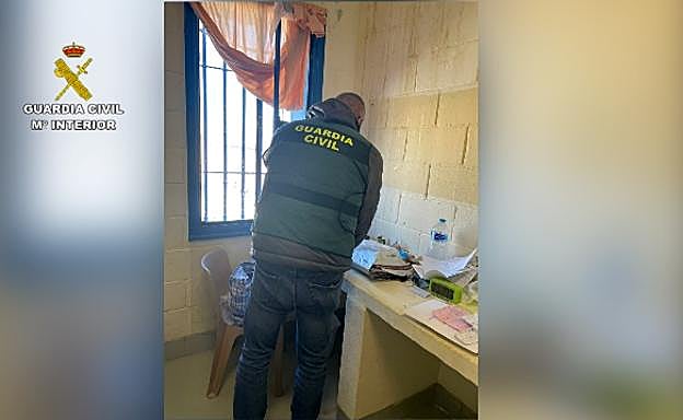 Un agente de la Benemérita realizando un registro en una celda.