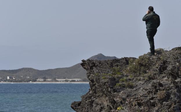 Un agente de la Guardia Civil, este domingo, en la zona donde desaparecieron los tripulantes de la patera naufragada.