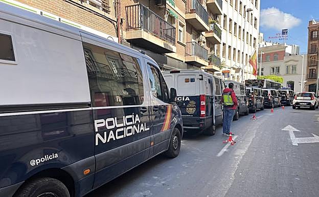 Caravana de furgonetas y un autobús de la Policía Nacional, utilizados para el traslado de los sospechosos de explotar inmigrantes. 