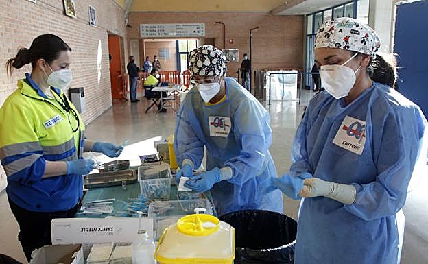 Galería. Dos enfermeras preparan inyecciones para vacunar. 
