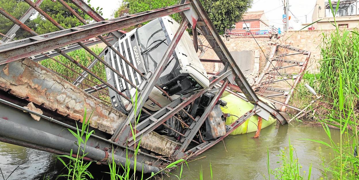 Casi un mes después, el puente y la hormigonera siguen hundidos en el cauce del río Segura, a su paso por la pedanía de El Raal y Beniel. 