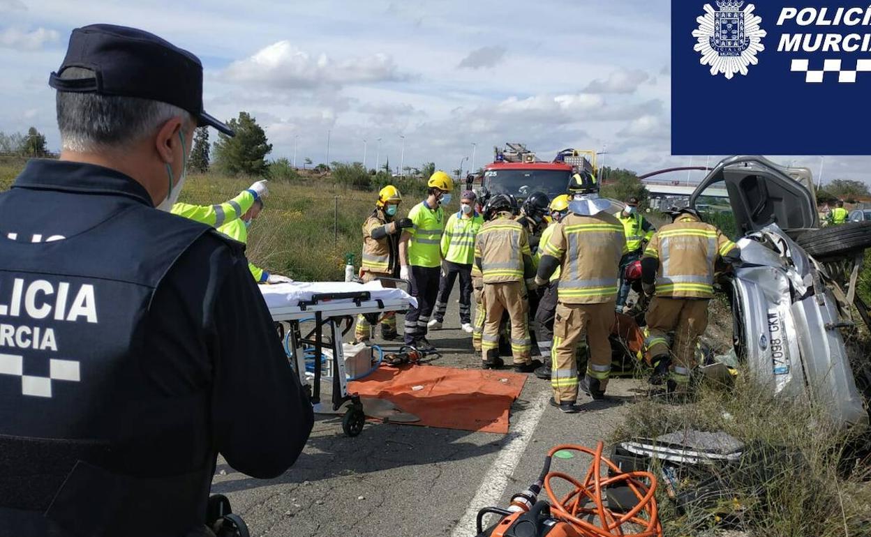 La Polícia Local de Murcia, bomberos y Guardia Civil en el rescate de los ocupantes del turismo.