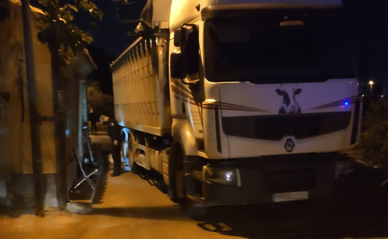 Un agente inspecciona la zona donde fue atropellado el menor, junto al camión parado frente a la vivienda familiar. 