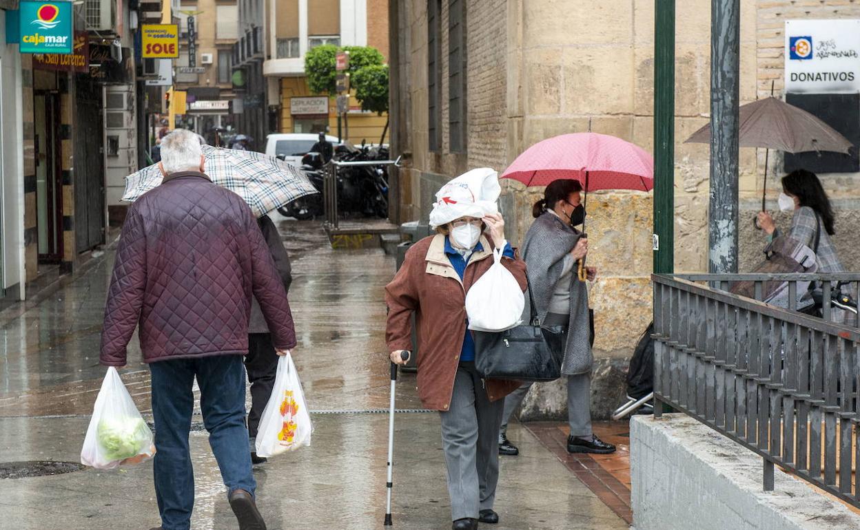 Varias personas se protegen de la lluvia, en una imagen de archivo.