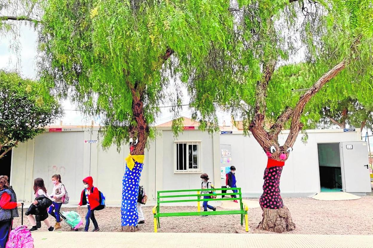 Un grupo de alumnos sale de un aula prefabricada instalada en el patio del colegio El Bohío. 
