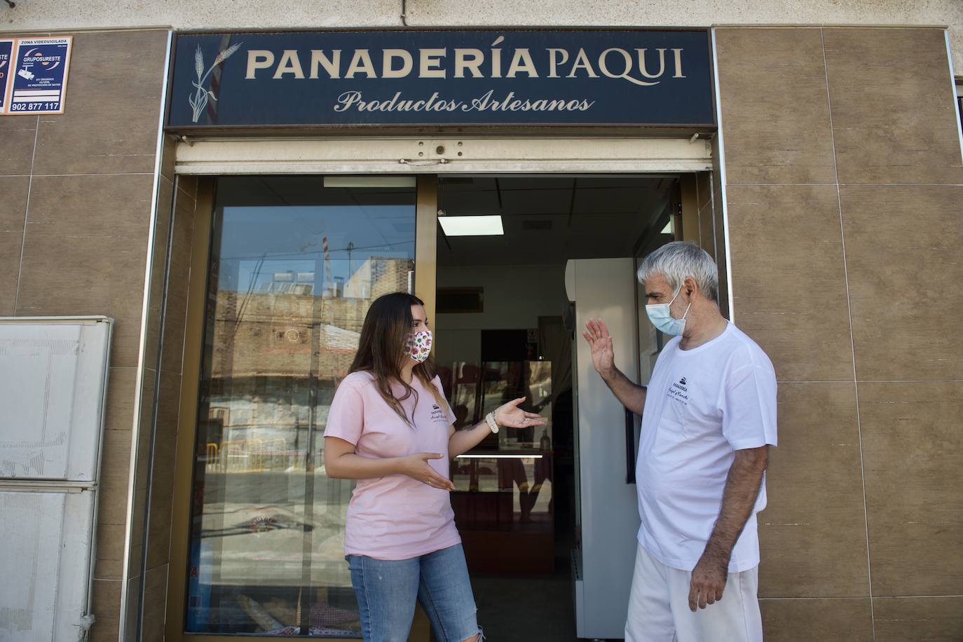 Ángel García habla con su hija a las puertas de la panadería que tiene que abandonar por las obras. 