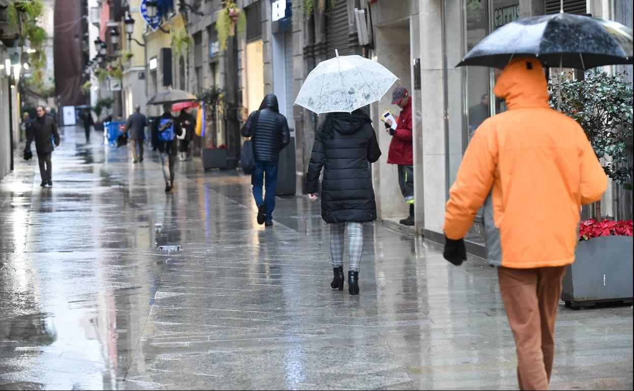 Vecinos de Murcia se protegen de la lluvia, en una fotografía de archivo.