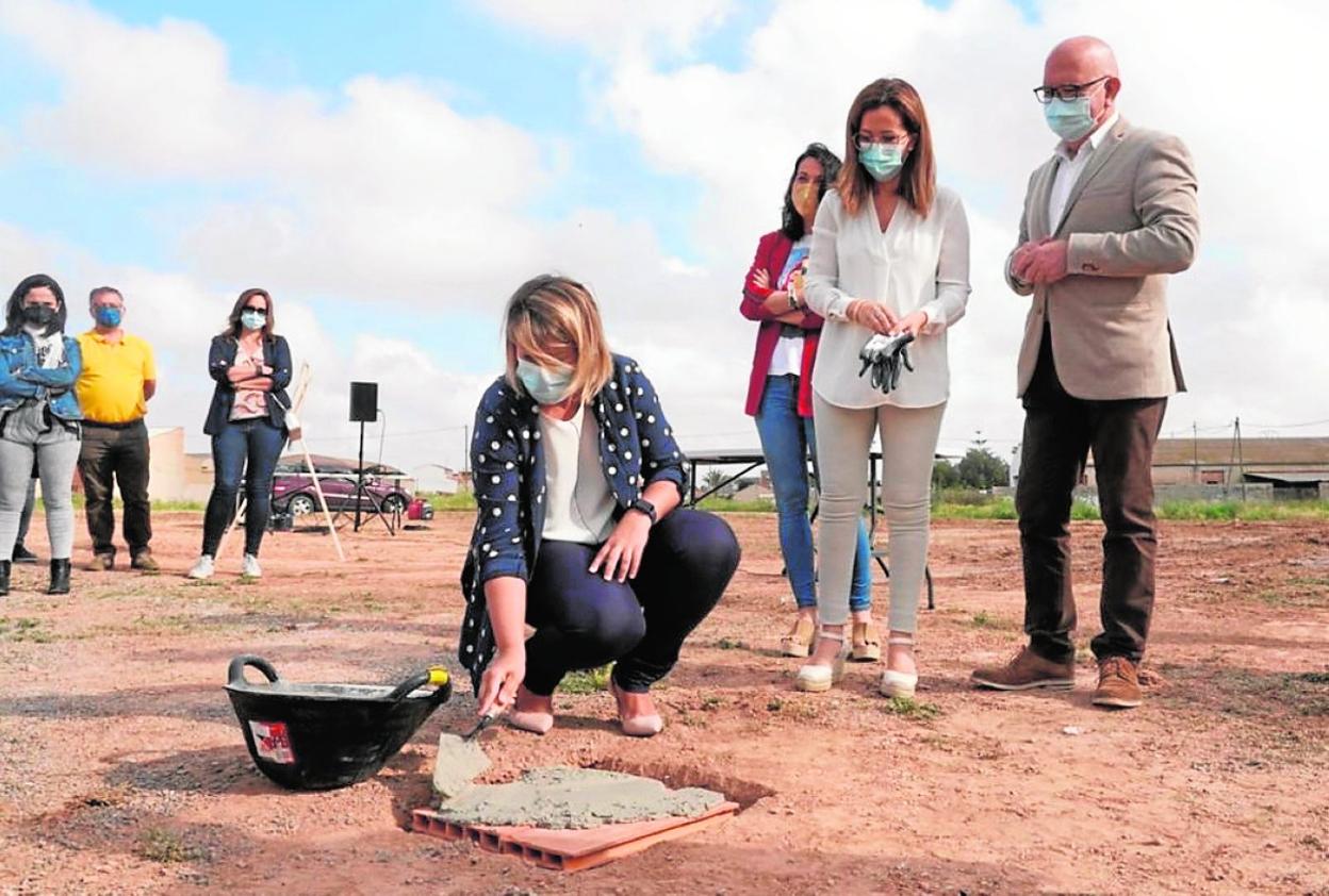 Castejón y otras personas observan cómo la vicealcaldesa, Noelia Arroyo, ayuda a poner la primera piedra. 