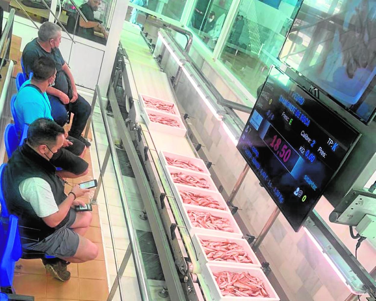 Tres propietarios de restaurantes pujan en la subasta celebrada en la lonja de Mazarrón, ayer. 