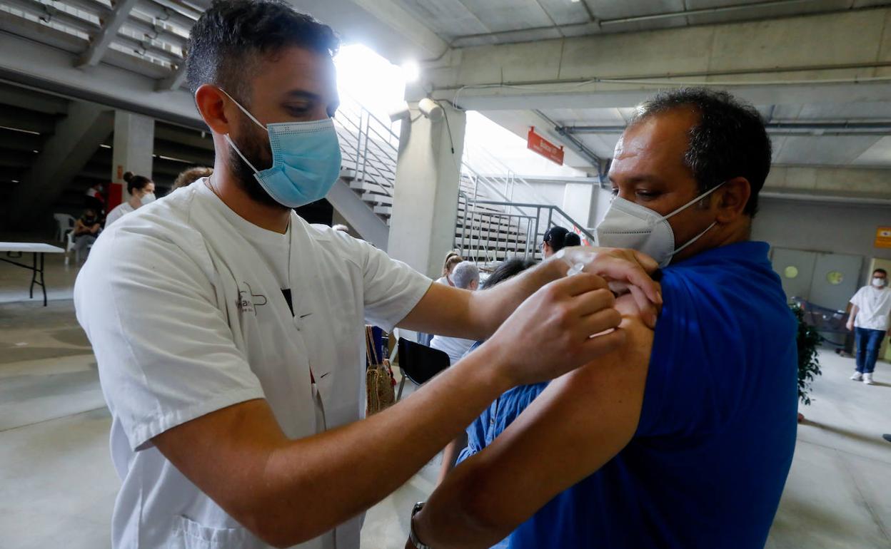 Un sanitario administra una dosis de la vacuna de Pfizer a un vecino del grupo de entre 40 y 49 años, este viernes, en el estadio Enrique Roca.