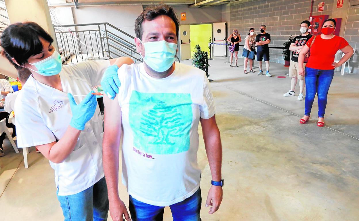 Una enfermera administrando vacunas, ayer, en el estadio Enrique Roca, en Murcia. 