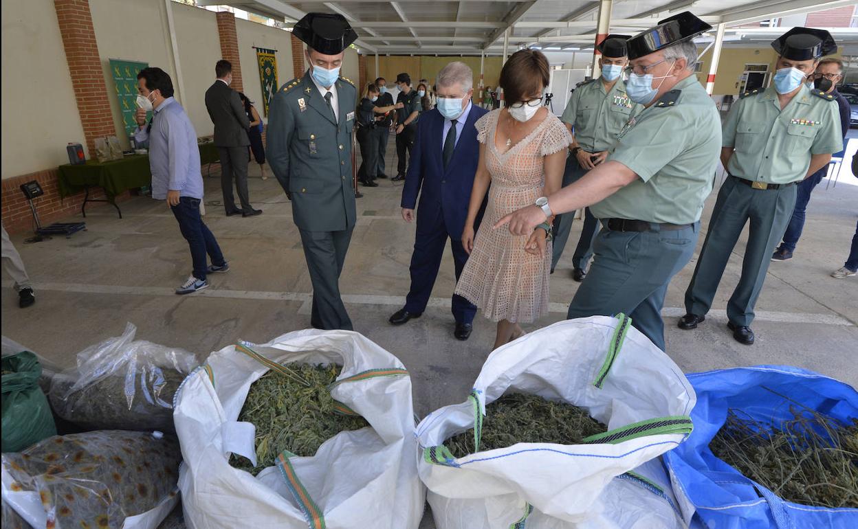 La directora general de la Guardia Civil, María Gámez, junto a agentes de la Guardia Civil, frente a los sacos de droga intervenidos por la Guardia Civil durante la operación.