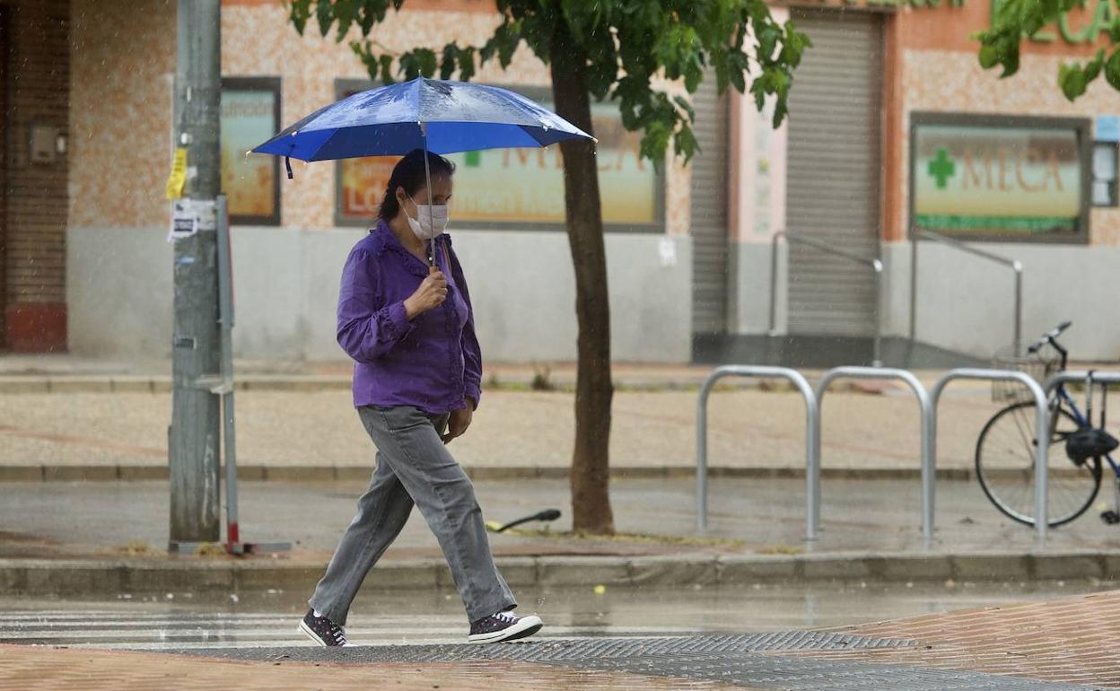 Una mujer pasea bajo la llvia con su paraguas, en una imagen de archivo.