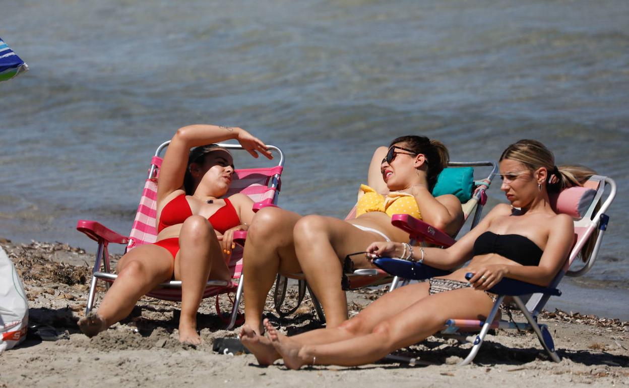 Tres chicas tomando el sol en una playa de la Región de Murcia.