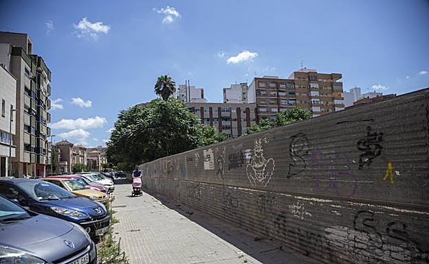 Un hombre, con un carricoche por la calle Alfonso X, en el Ensanche.