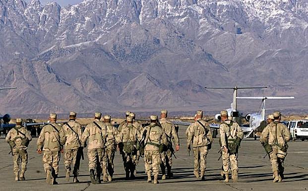 Los soldados estadounidenses se acercan a los aviones de las Naciones Unidas en la pista de la base aérea de Bargam en Bagram 