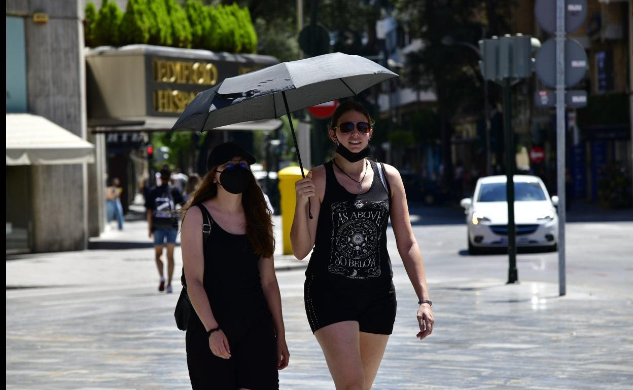 Dos mujeres se protegen del sol con un paraguas este sábado en Murcia. 