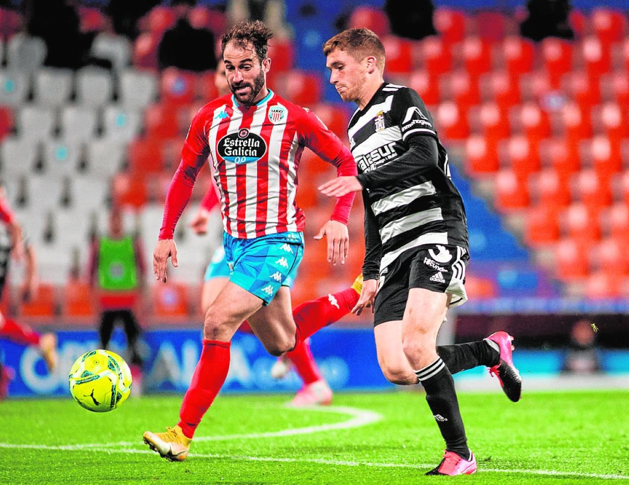 Teddy conduce el balón perseguido por Felipe Venancio, defensa del Lugo, en el Anxo Carro. 