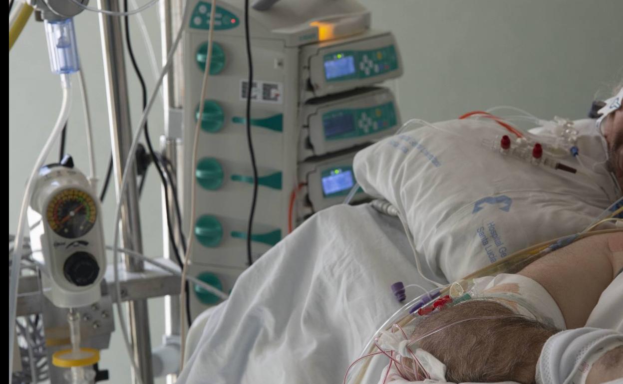 Una sanitaria atiende a un enfermo en una UCI del hospital Santa Lucía de Cartagena. 