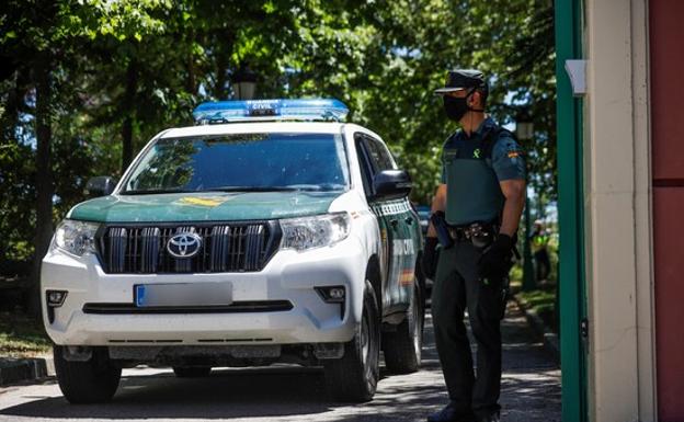 Foto de archivo de un coche de la Guadia Civil, junto con un agente. 