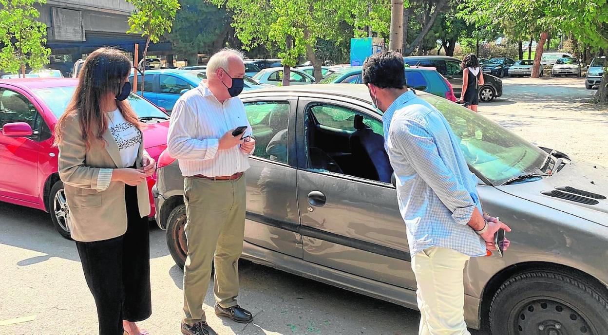 Rebeca Pérez, Martínez Oliva y Diego Avilés observan los desperfectos en un coche en la zona de El Malecón. 