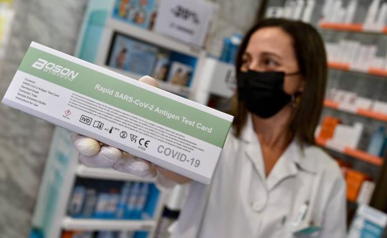 Una farmacéutica muestra un test de antígenos, en una imagen de archivo.