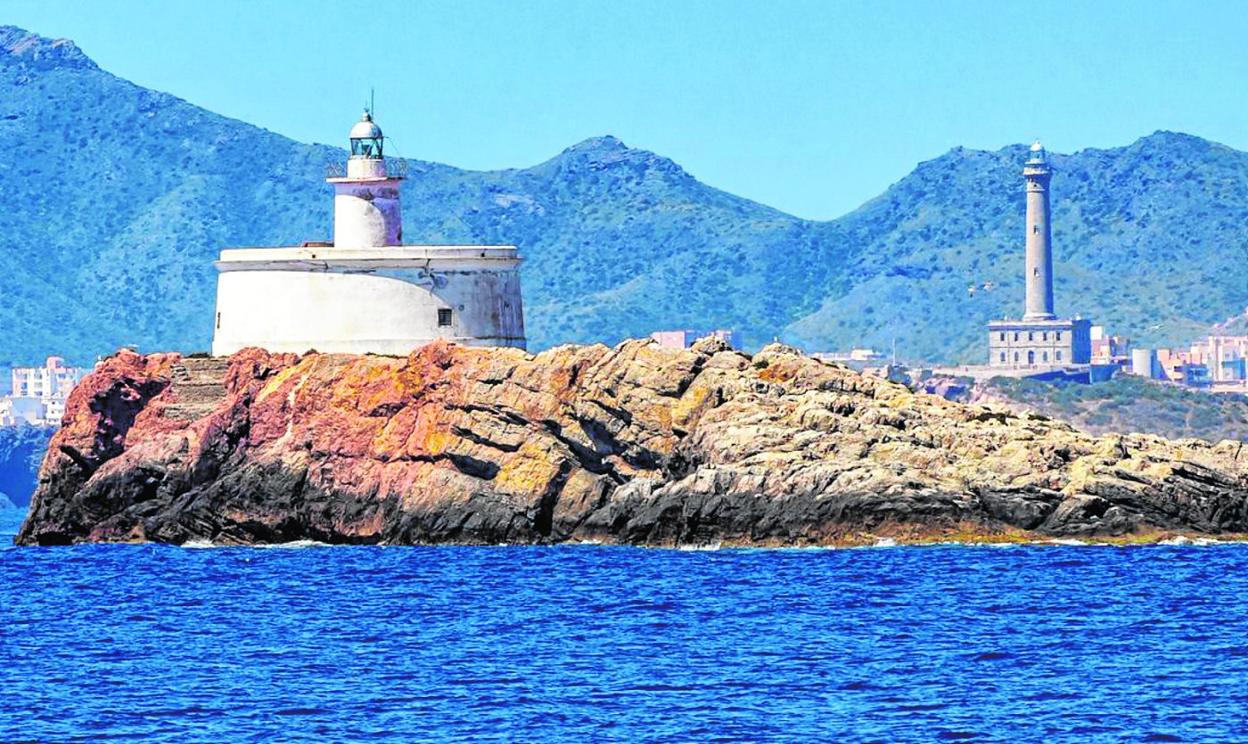 El faro del islote La Hormiga, con el de Cabo de Palos al fondo. Abajo, la linterna, que tiene un alcance de 8 millas náuticas. 