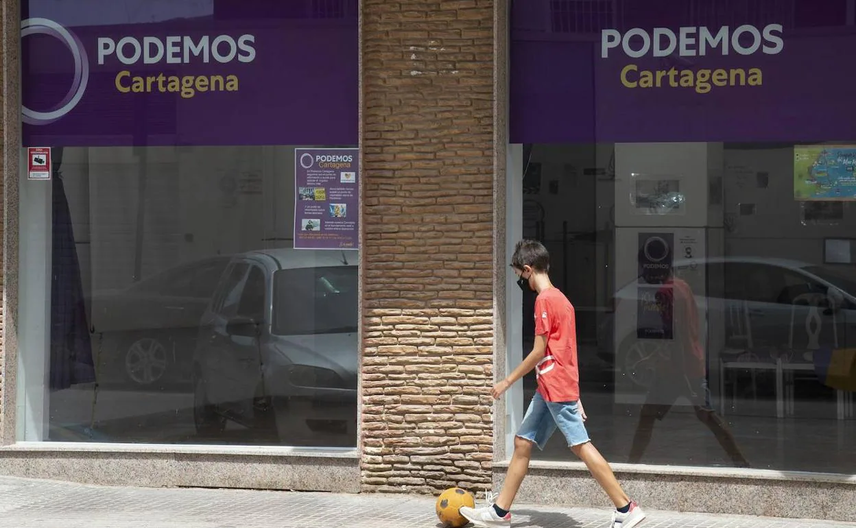 Sede de Podemos en Cartagena, este miércoles, con un cartel sobre las videocámaras (izquierda). 