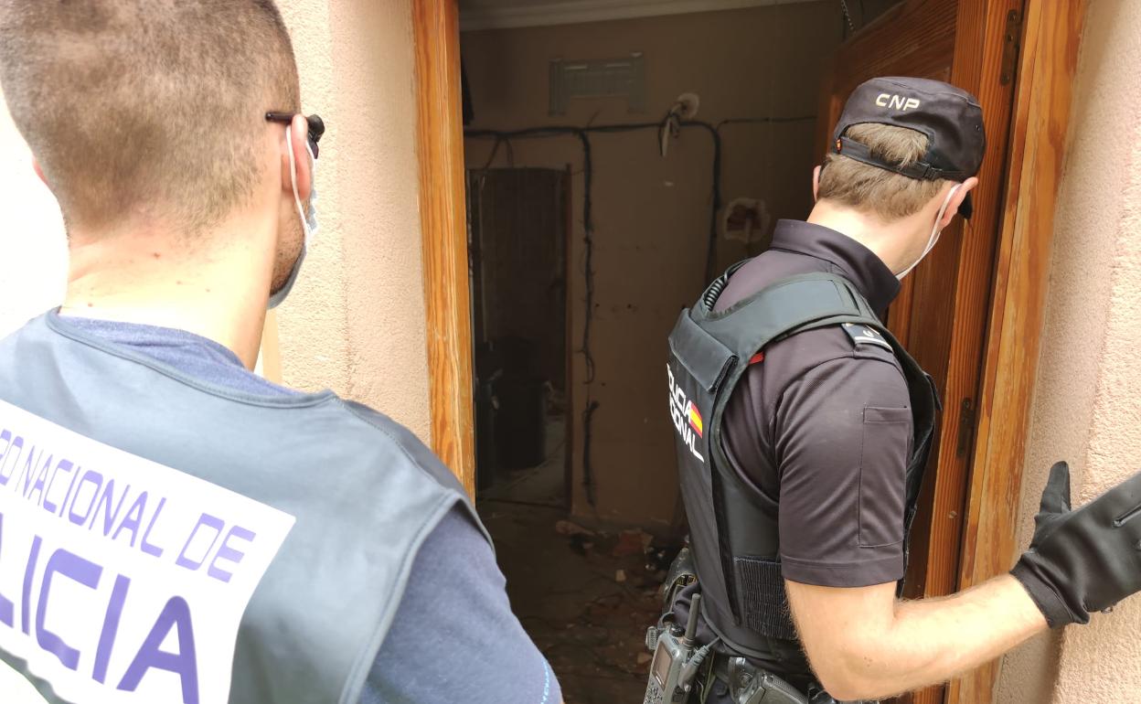 Dos agentes acceden a una de las casas para realizar un registro, ayer.