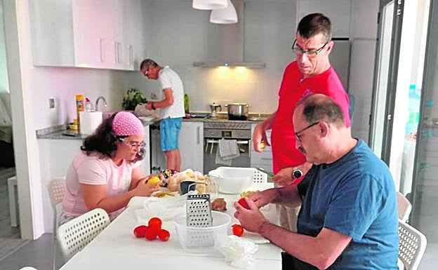 Los usuarios del piso tutelado desayunan en la cocina. 