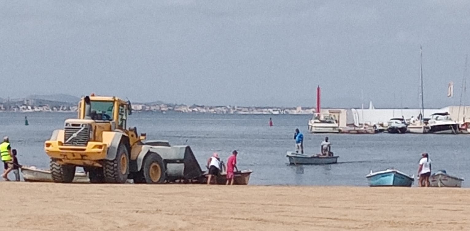 Los pescadores ayudan a sacar peces con sus redes.
