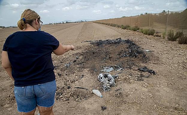 Nany García señala el lugar donde ardió el coche.