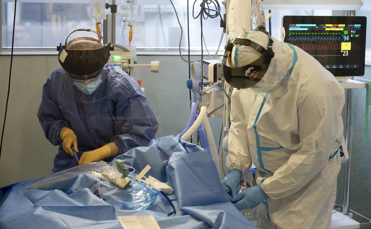 Dos sanitarios atienden a un paciente en la UCI del hospital Santa Lucía de Cartagena, en una fotografía de archivo.