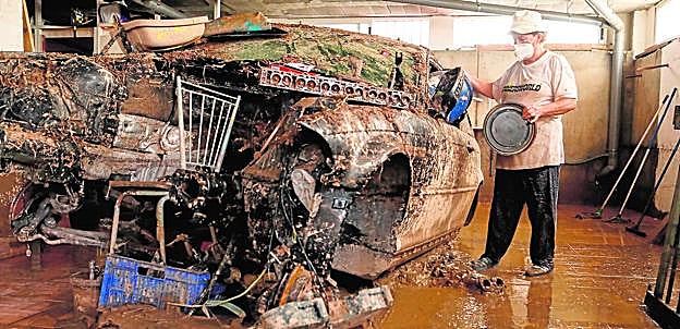 Juani Díaz, ayer por la mañana, limpia el garaje de su casa, que quedó destrozado tras el desbordamiento de la rambla del Cañarete. 