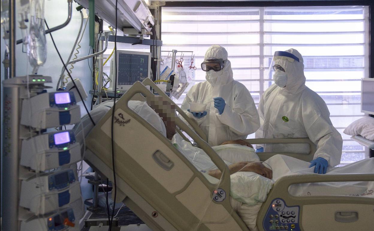 Dos sanitarios atienden a un paciente en la UCI del hospital Morales Meseguer, en Murcia, en uan fotografía de archivo.