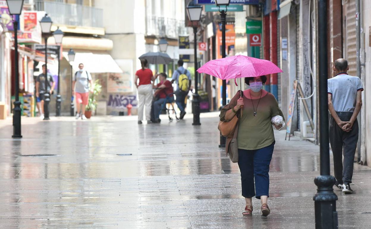 Una vecina de Murcia pasea bajo la lluvia en una imagen de archivo.