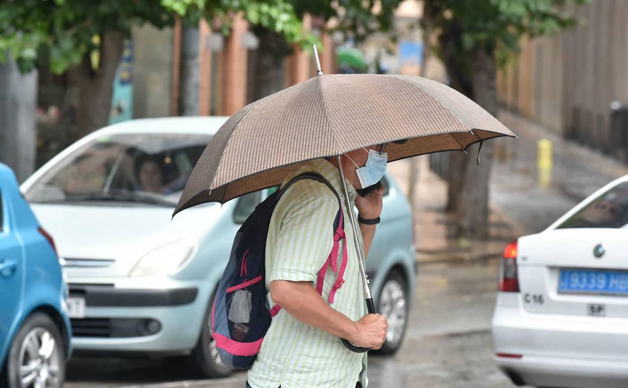 Un hombre se protege de la lluvia con un paraguas, en una imagen de archivo.
