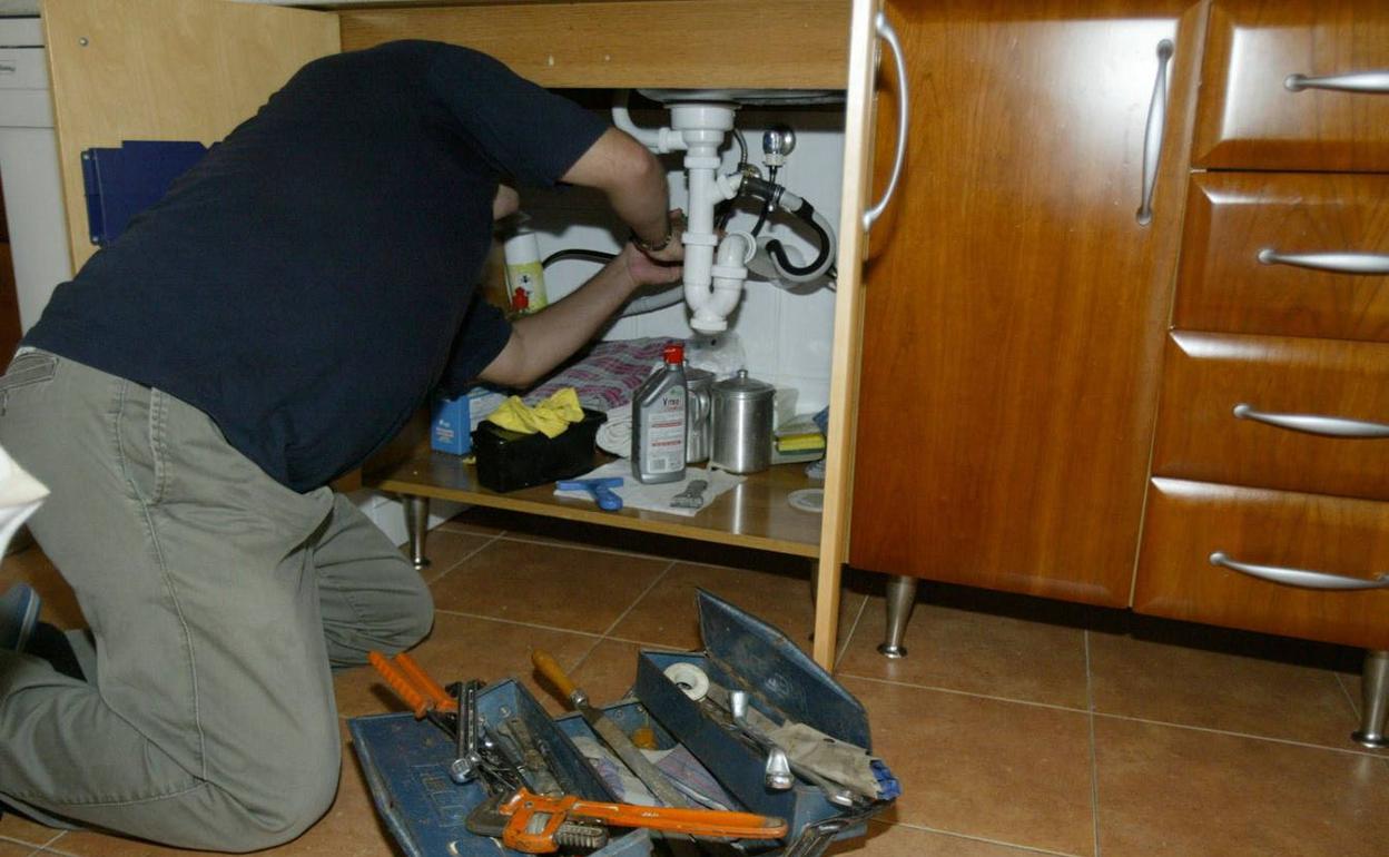 Imagen de archivo de un fontanero reparando una avería. 