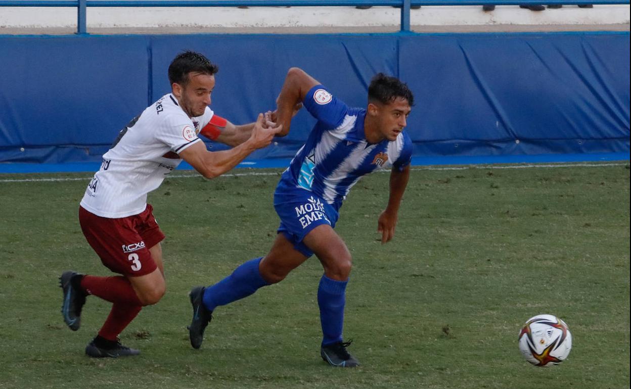 Abel, capitán del Alzira, agarra a Javi Pérez en una jugada del partido de ayer en El Rubial.