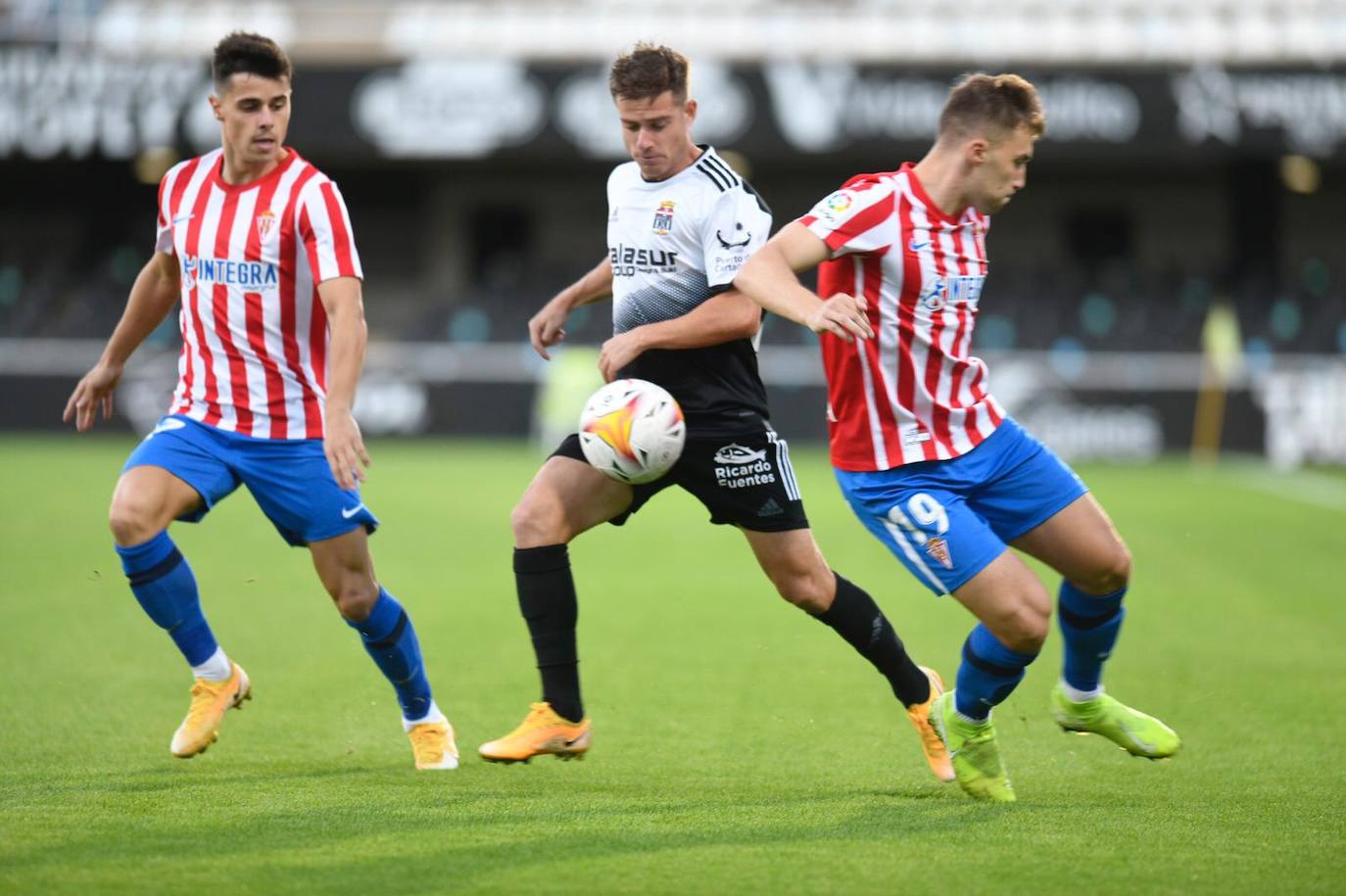 Un jugador del Cartagena se interna en la zaga del Sporting de Gijón.