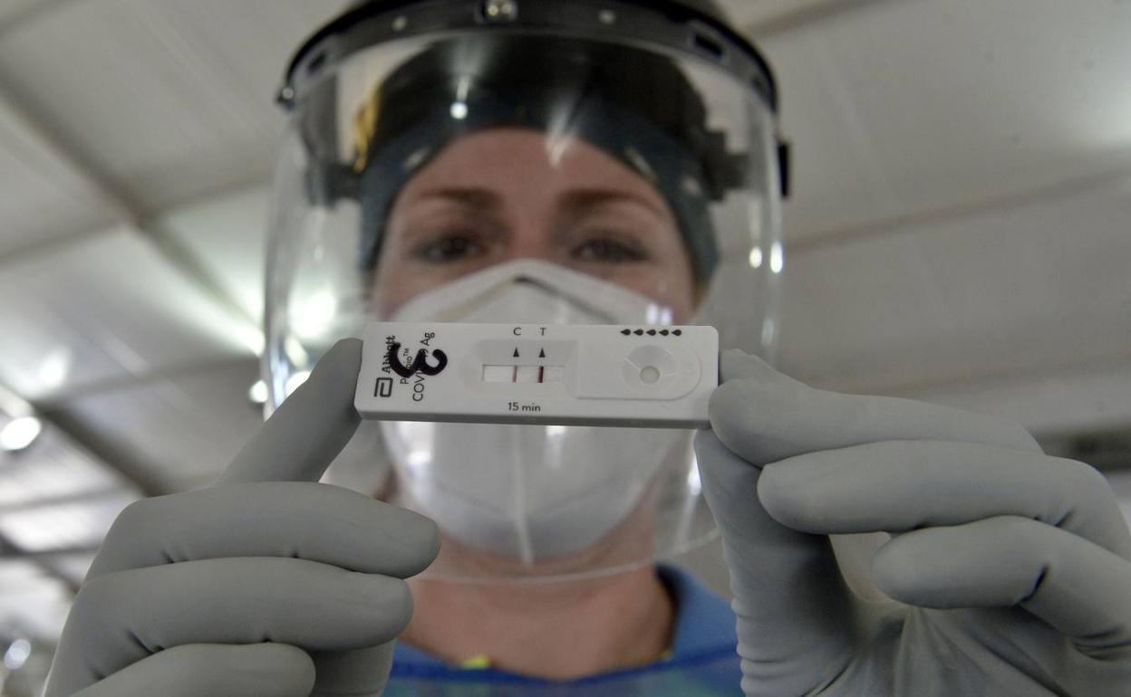 Un sanitario muestra un test positivo en una imagen de archivo. 