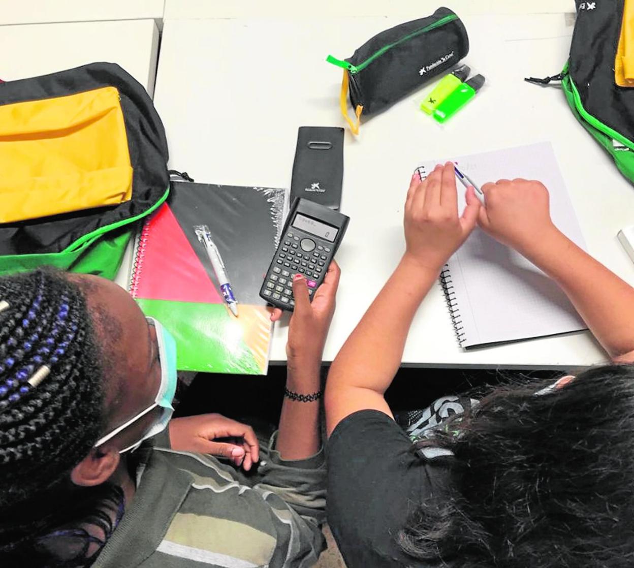 Dos niños utilizan el material escolar que se incluye en los kits de la Fundación 'la Caixa'.