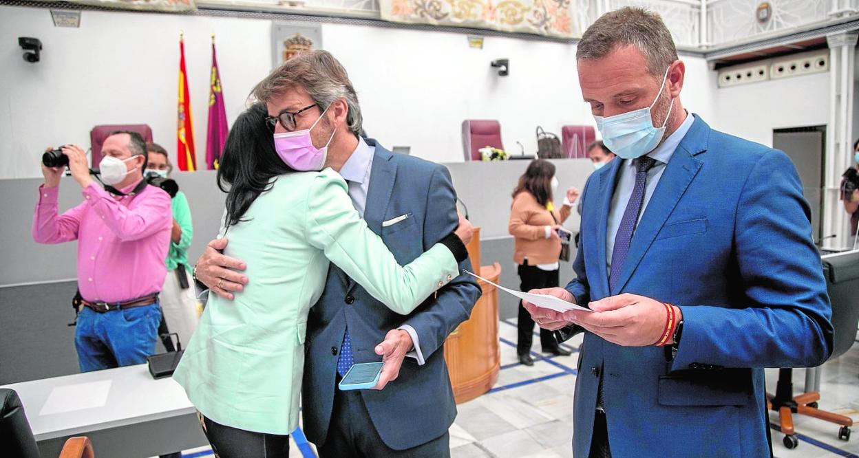 El consejero de Hacienda, Luis Alberto Marín, abraza a Valle Miguélez en la Asamblea, en presencia de Joaquín Segado. 