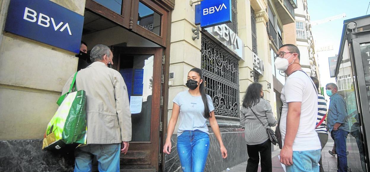 Clientes aguardan su turno para entrar en una sucursal bancaria del centro de Murcia durante el segundo estado de alarma. 