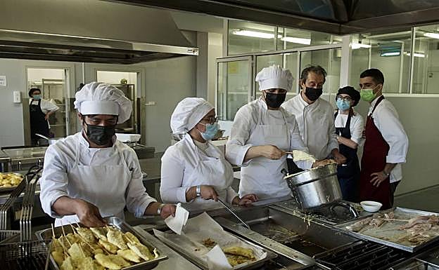 Varios voluntarios, en las cocinas de Región de Murcia Gastronómica junto al chef de El Churra, Juan Antonio García (d).