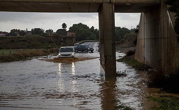 Un vehículo trata de cruzar el camino del Sifón, ayer, anegado tras la tormenta. 