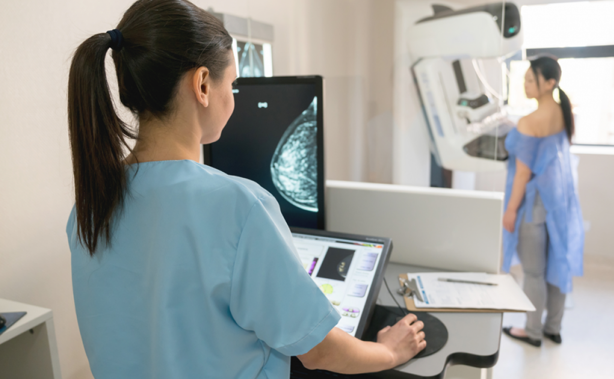 Una sanitaria realizando una mamograía a una paciente.