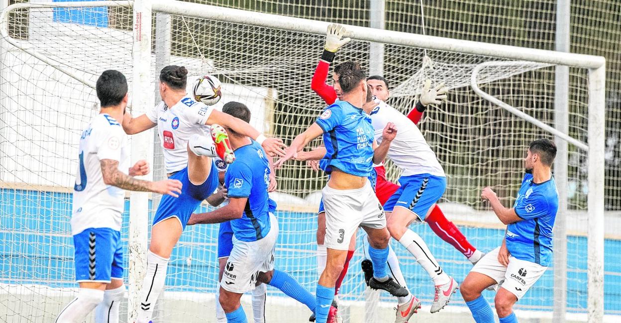 Los jugadores del Puertollano observan cómo Molinero, del Mar Menor, marca el gol que provocó su derrota el pasado domingo en San Javier. 